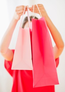 Portrait of young woman with shopping bags. Photo : Daniel Grill