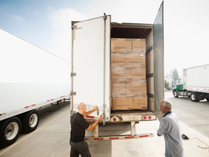 Two men close in truck trailer.