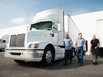 Three men walking between trucks.
