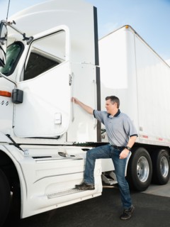 Truck driver entering truck.