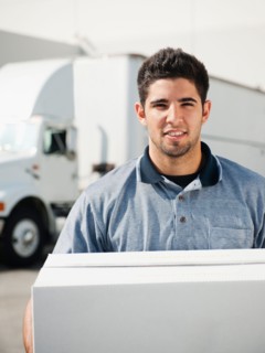 Man carrying box in warehouse.
