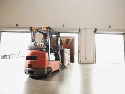 Forklift driver working in warehouse.