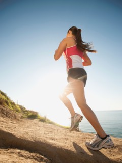 USA, California, San Diego, Woman jogging along sea coast.