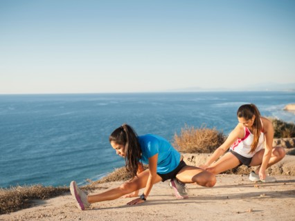 USA, California, San Diego, Two women stretching at sea coast.