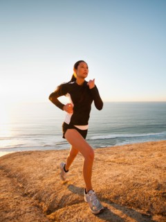 USA, California, San Diego, Woman jogging along sea coast.