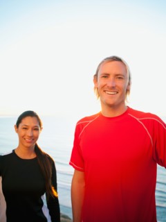 Portrait of male and female joggers at sea.