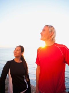 Portrait of male and female joggers at sea.