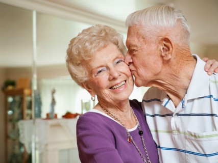 Senior man kissing woman.