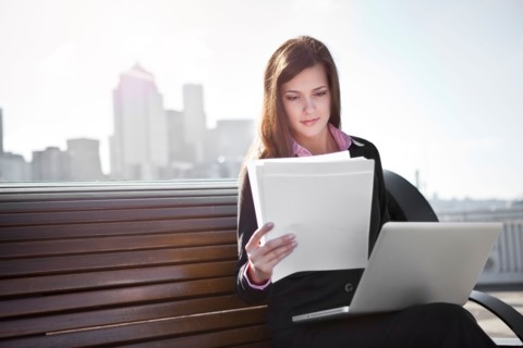 USA, Seattle, Young businesswoman sitting on bench and working. Photo : Take A Pix Media