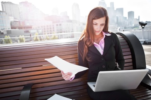 USA, Seattle, Young businesswoman sitting on bench and working. Photo : Take A Pix Media