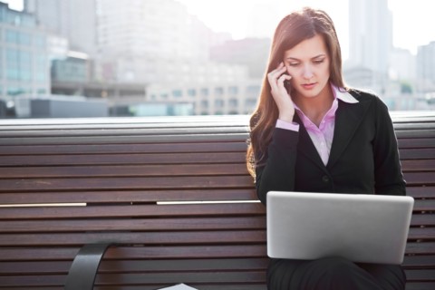 USA, Seattle, Young businesswoman sitting on bench and working. Photo : Take A Pix Media