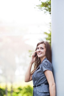 Young elegant woman standing and talking via phone. Photo : Take A Pix Media
