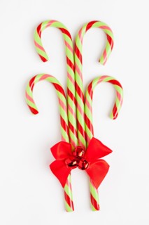 Striped candy canes with red ribbon, studio shot. Photo : Sarah M. Golonka