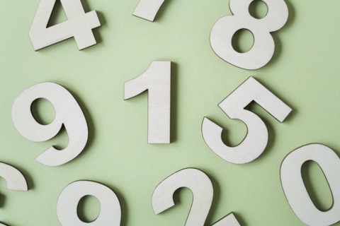 Numbers on white background, studio shot. Photo : Kristin Lee