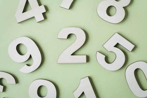Numbers on white background, studio shot. Photo : Kristin Lee