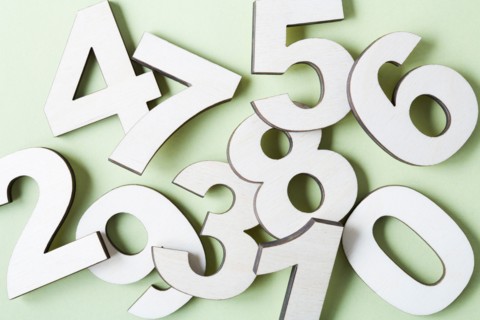 Numbers on white background, studio shot. Photo : Kristin Lee