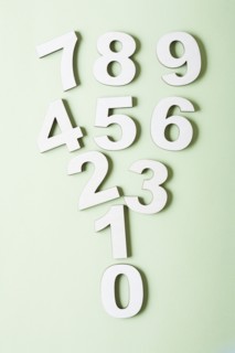 Numbers on white background, studio shot. Photo : Kristin Lee