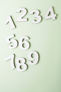 Numbers on white background, studio shot. Photo : Kristin Lee