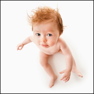 High angle view of baby girl (6-11 months) sitting, studio shot. Photo : Mike Kemp