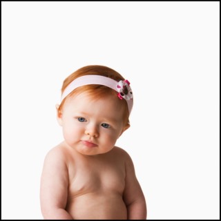 Portrait of baby girl (6-11 months), studio shot. Photo : Mike Kemp