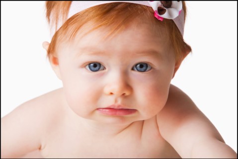 Portrait of baby girl (6-11 months) looking at camera, studio shot. Photo : Mike Kemp