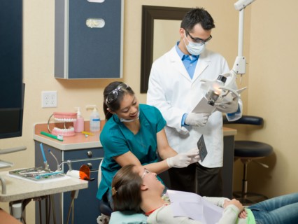 Dentists and patient in dental surgery. Photo : Dan Bannister