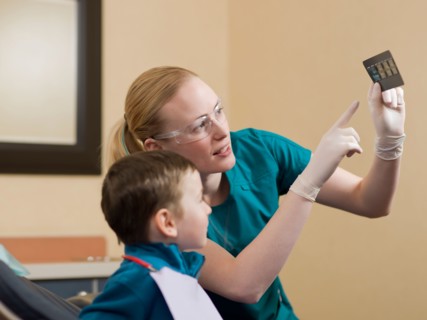 Dentists showing x-ray image to patient. Photo : Dan Bannister