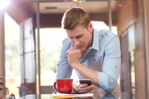 Man texting at home. Photo : db2stock