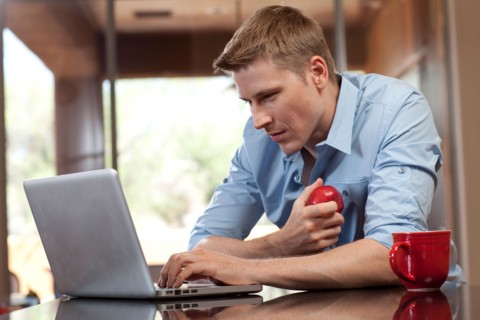 Man using laptop at home. Photo : db2stock