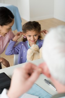 Girl (10-11) with mother in doctor's office. Photo : Rob Lewine
