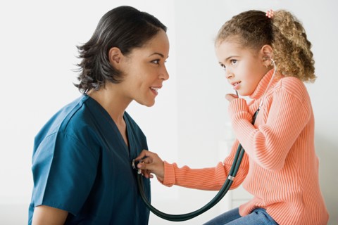 Girl (10-11) examining doctor. Photo : Rob Lewine