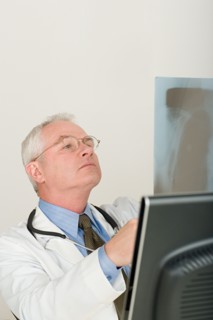Doctor looking at x-ray image. Photo : Rob Lewine