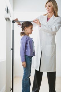 Doctor measuring girl (10-11). Photo : Rob Lewine