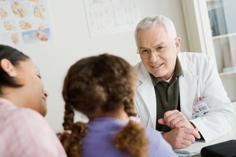 Girl (10-11) with mother talking to doctor. Photo : Rob Lewine