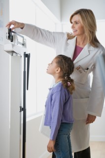 Doctor weighting girl (10-11). Photo : Rob Lewine