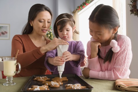 Mother and daughters (10-11) preparing cakes. Photo : Rob Lewine