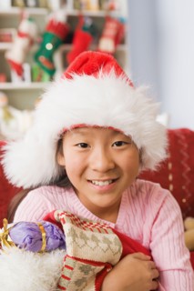 Portrait of teenage Girl (10-11) wearing santa hat. Photo : Rob Lewine