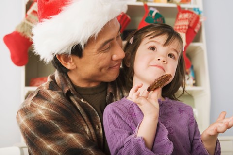 Girl and father wearing santa hat. Photo : Rob Lewine