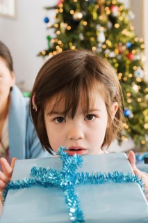 Girl holding christmas present. Photo : Rob Lewine