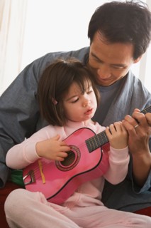 Father and daughter playing guitar. Photo : Rob Lewine