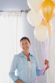 Portrait of mature woman with balloons. Photo : Rob Lewine