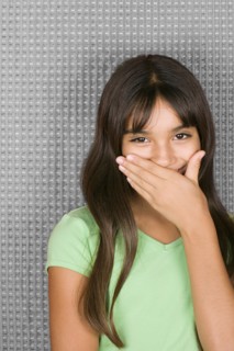 Laughing teenage girl with hands over mouth. Photo : Rob Lewine