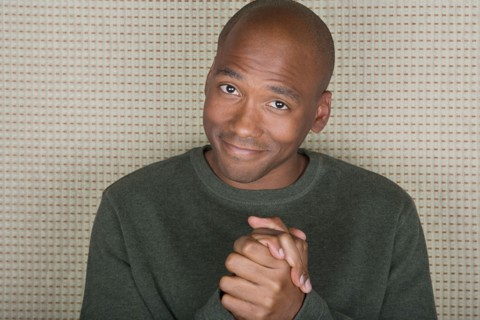 Studio portrait of mid adult man with hands clasped. Photo : Rob Lewine