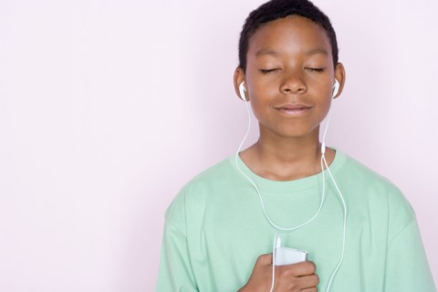 Studio portrait of teenage boy listening to music. Photo : Rob Lewine