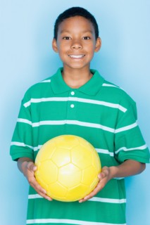 Studio portrait of teenage boy holding ball. Photo : Rob Lewine