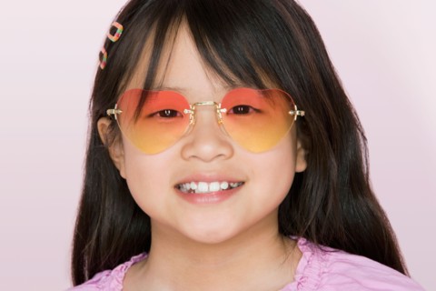 Studio portrait of girl wearing heart-shaped glasses. Photo : Rob Lewine