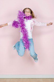 Studio shot portrait of jumping teenage girl in feather boa shawl, full length. Photo : Rob Lewine