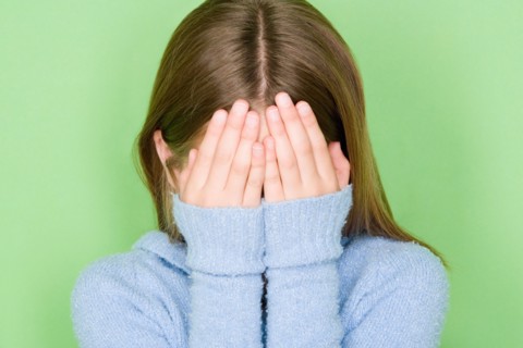 Studio shot portrait of teenage girl covering face, head and shoulders. Photo : Rob Lewine