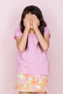 Studio shot portrait of teenage girl covering face, three quarter length. Photo : Rob Lewine
