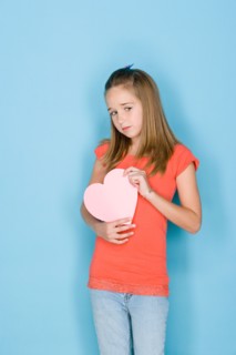 Studio shot portrait of teenage girl holding hart, three quarter length. Photo : Rob Lewine